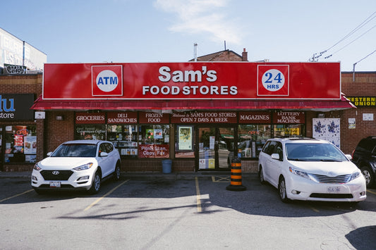 A sam's food store with cars parked in front of it